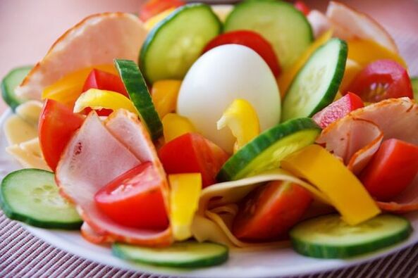 Ensalada de verduras en el menú dietético con huevos y naranja para adelgazar. 